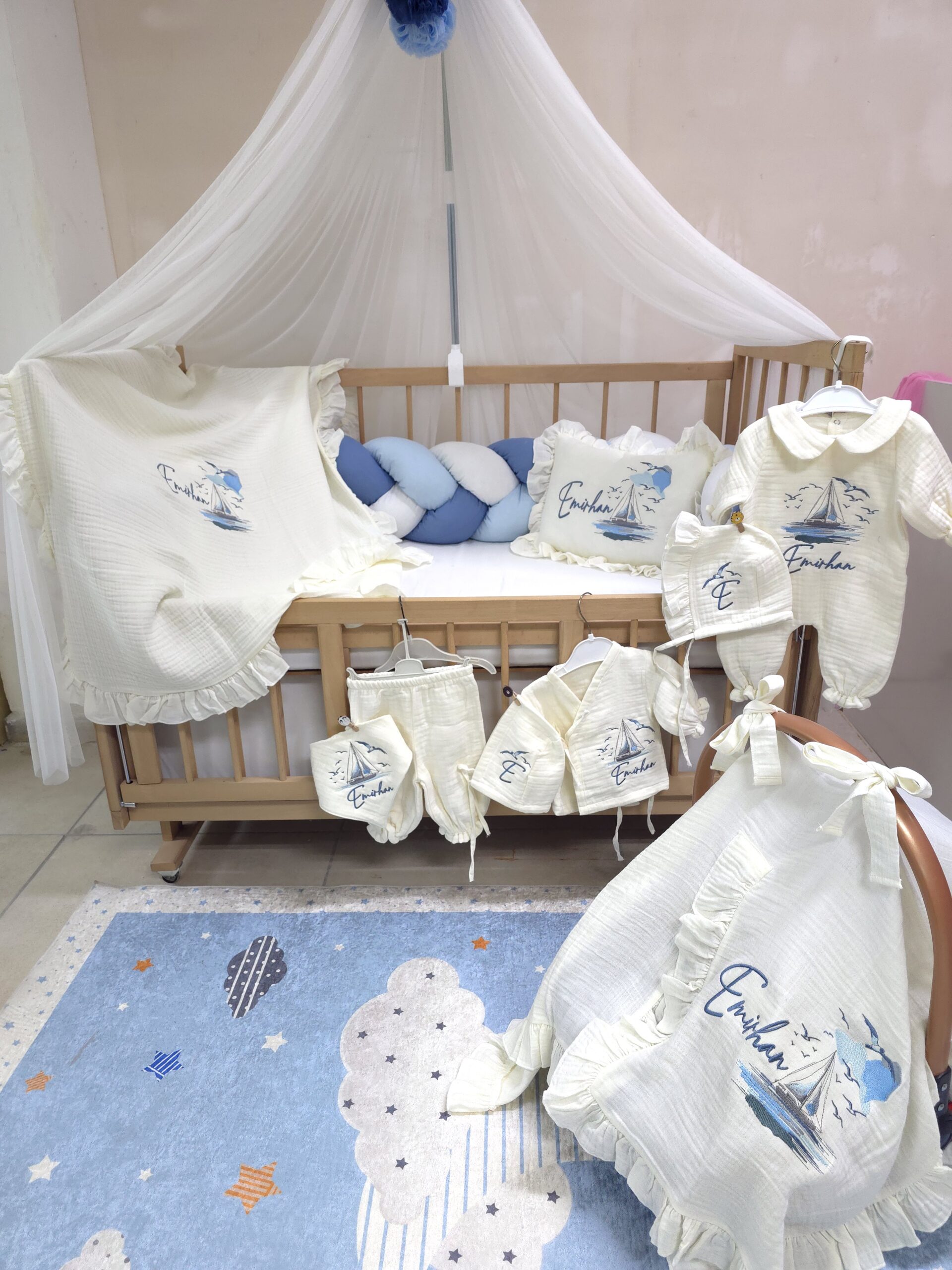 müslin-hastane-çıkışı-T13-(2) 4 katlı %100 pamuk müslin hastane çıkışı seti (0–3 ay); isimli nakışlı tulum, şapka, alt üst takım, eldiven, önlük, battaniye, puset örtüsü ve kırlent ile eksiksiz bir yenidoğan seti sunar.