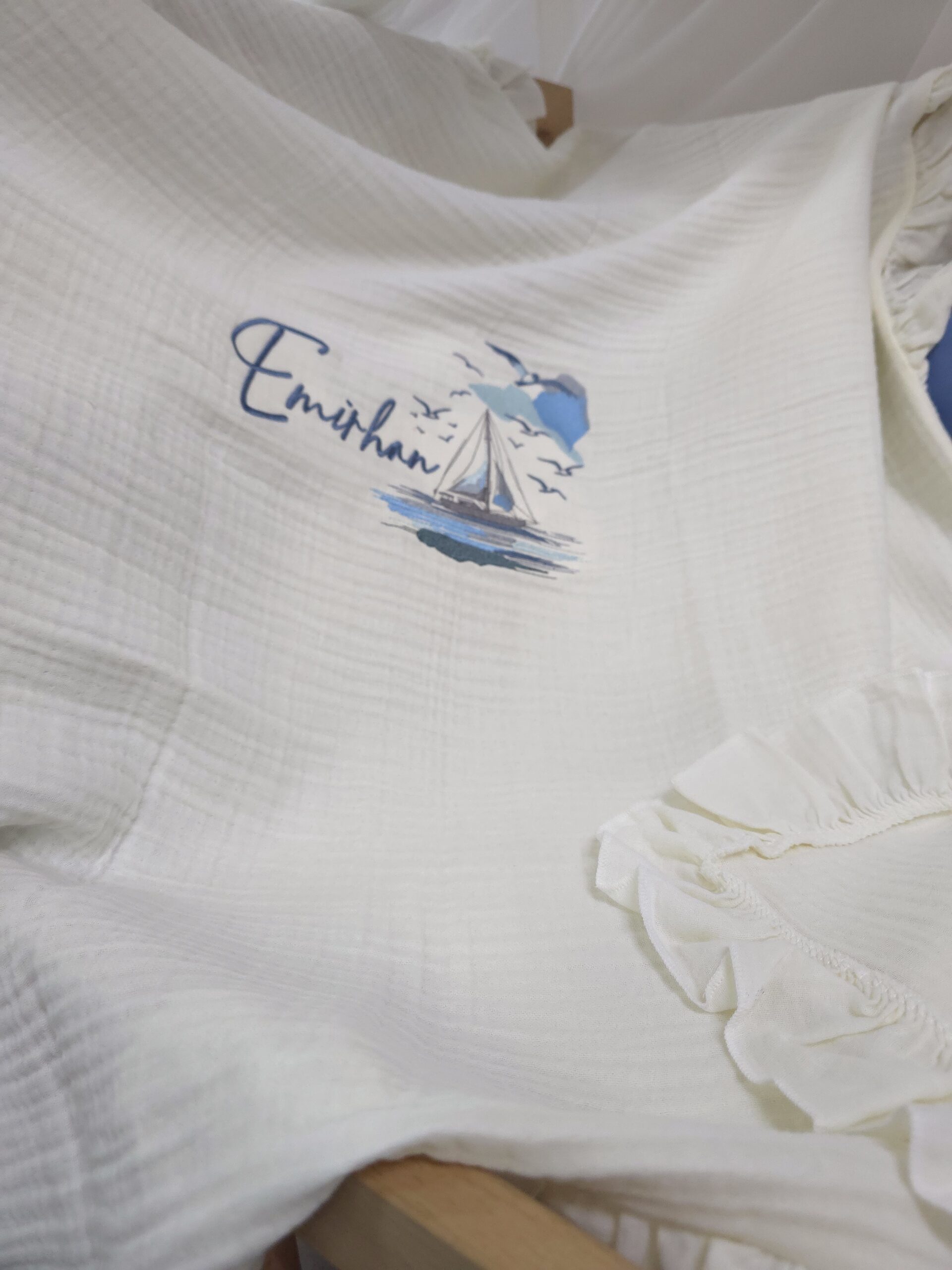 müslin-hastane-çıkışı-T13-(7) 4 katlı %100 pamuk müslin hastane çıkışı seti (0–3 ay); isimli nakışlı tulum, şapka, alt üst takım, eldiven, önlük, battaniye, puset örtüsü ve kırlent ile eksiksiz bir yenidoğan seti sunar.